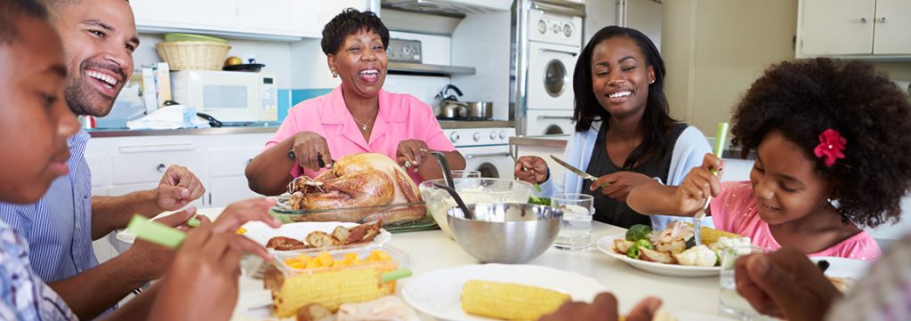Multi-Generation Family Sitting Around Table Eating Meal Multi-Generation Family Sitting Around Table Eating Meal
